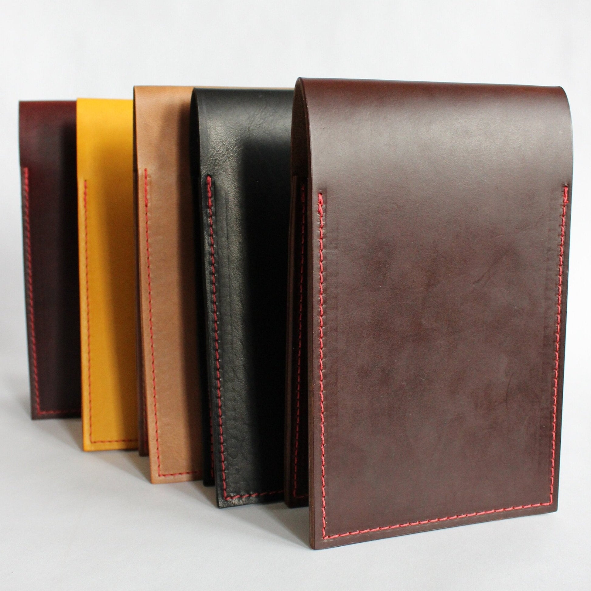 Set of leather yardage book covers in various colors on a white background