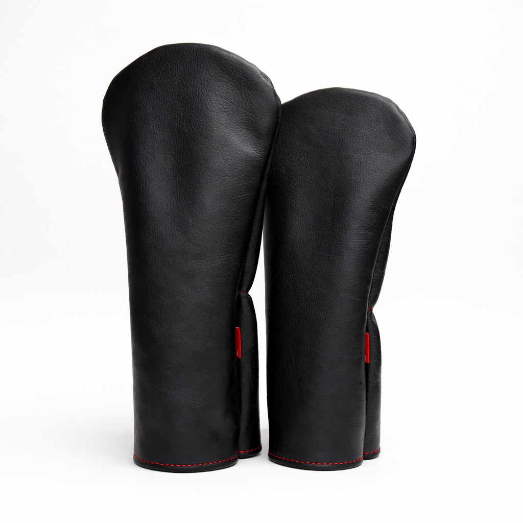 Pair of black leather boxing gloves with red accents on a white background