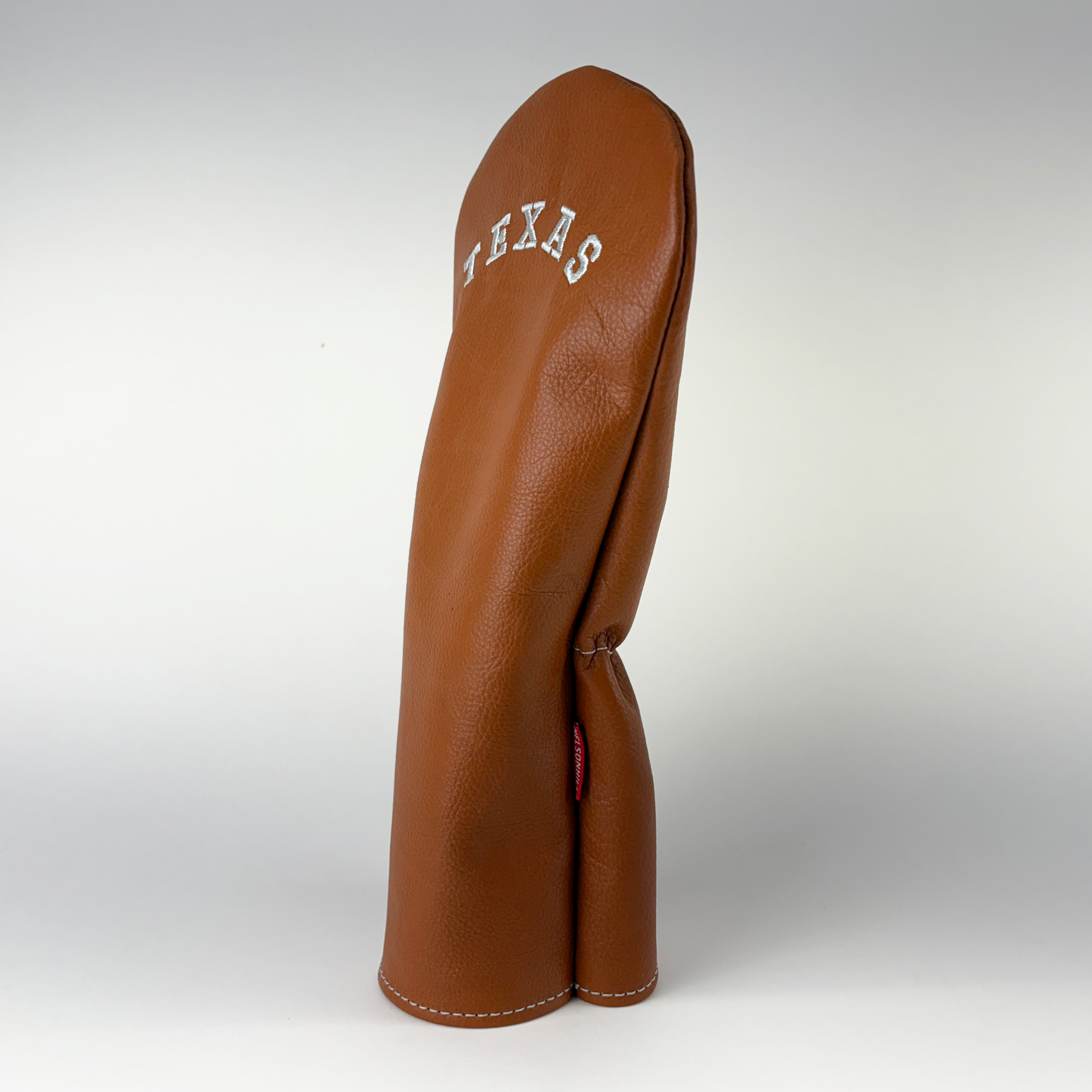Brown leather golf club head cover with 'Texas' branding on a white background