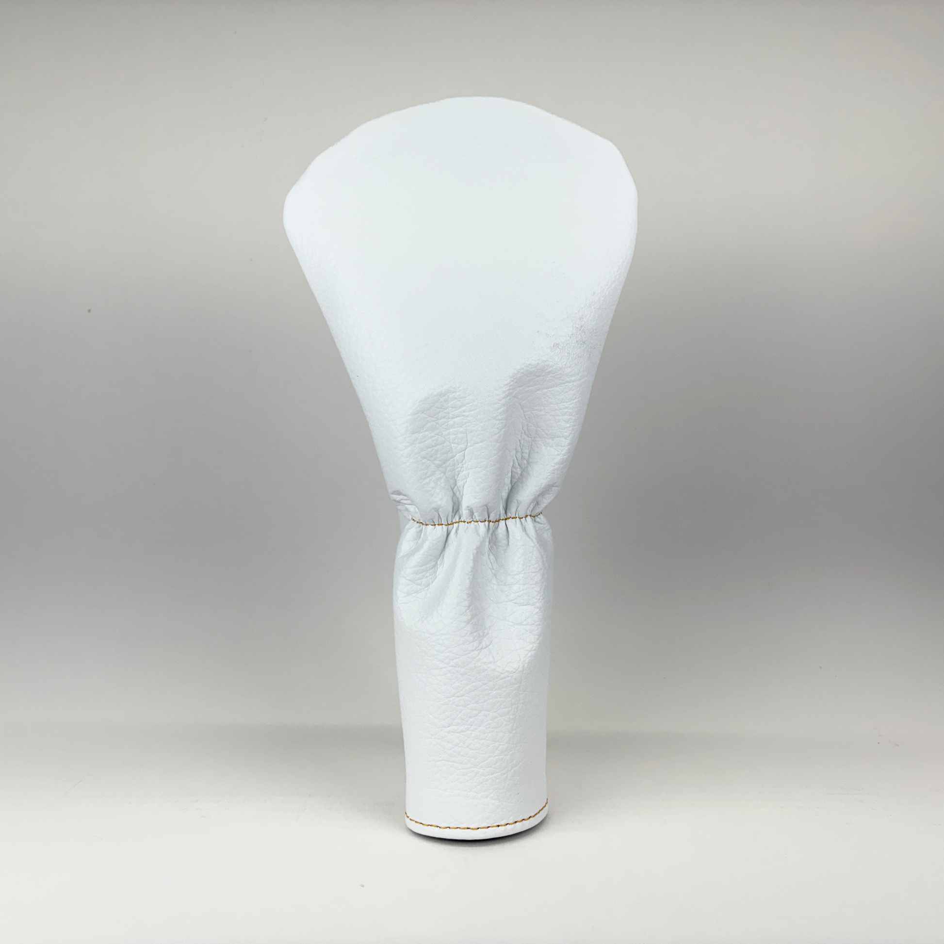 White golf club head cover on a gray background