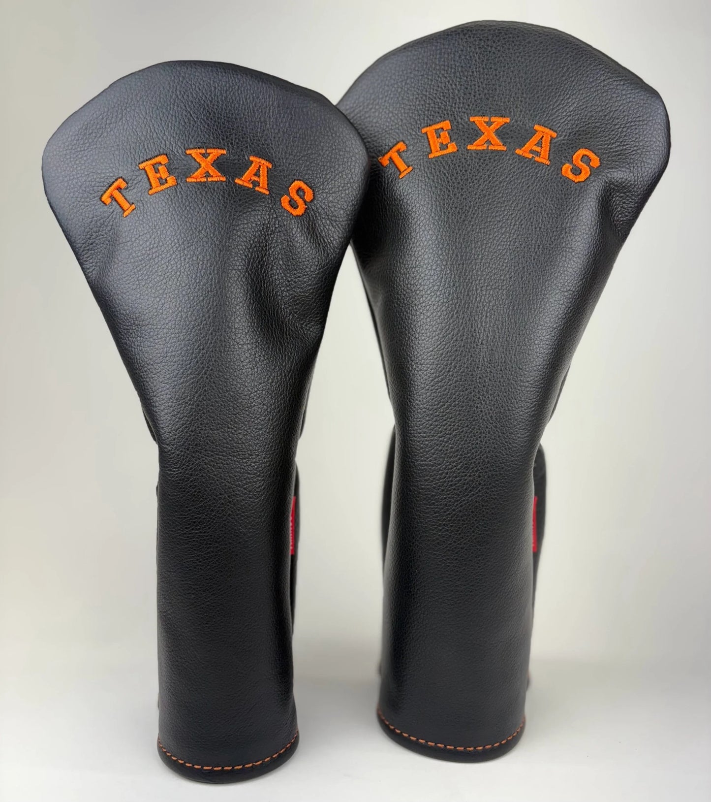 Two black golf club head covers with 'TEXAS' text on a white background