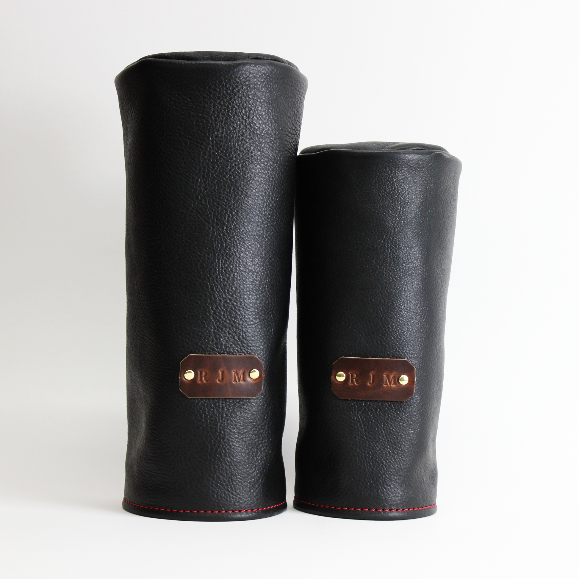 Black personalized barrel leather golf headcover set on a white background