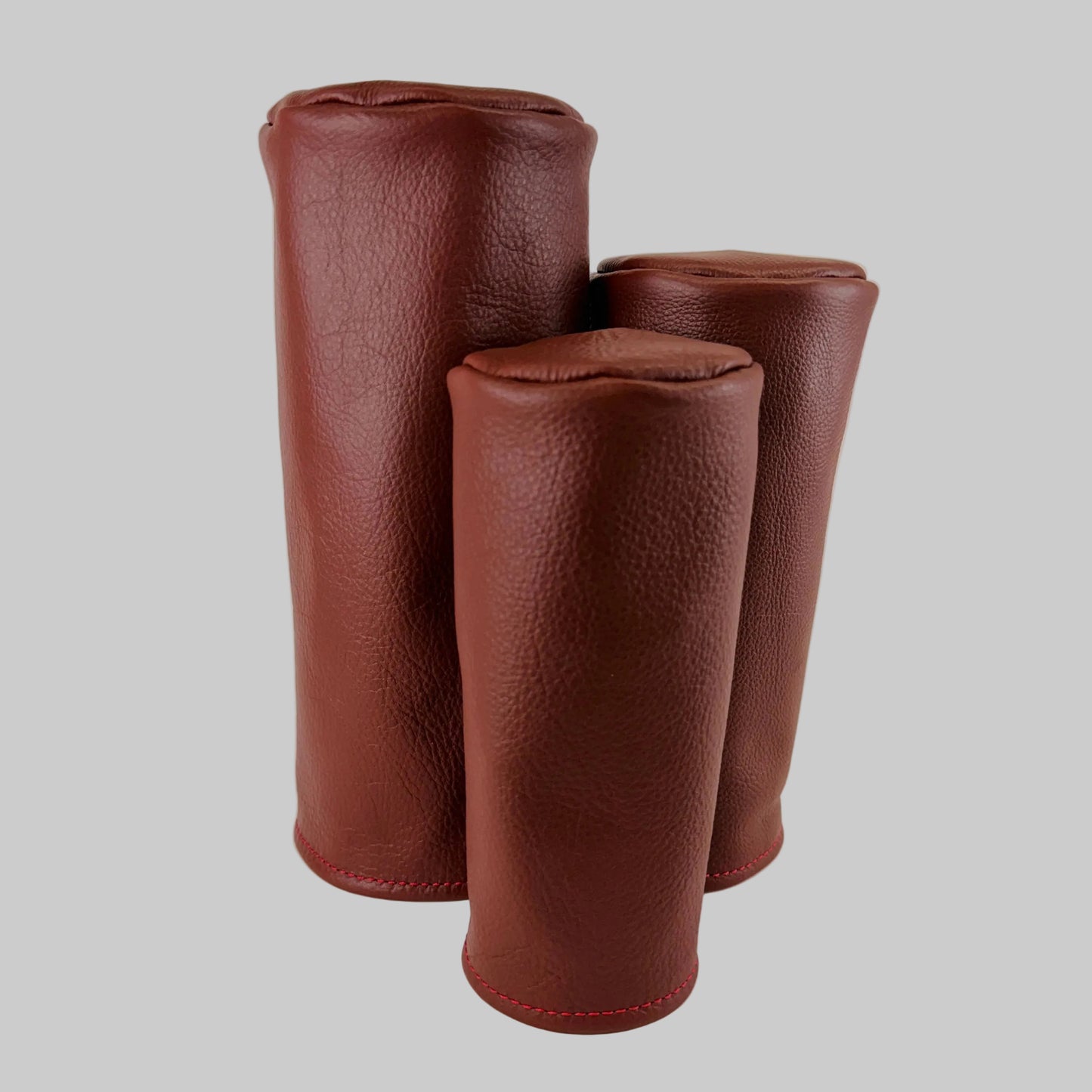 Brown barrel leather golf headcover set on a white background